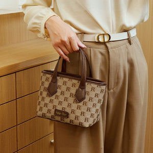 tan crossbody bag featuring top handles and monogram