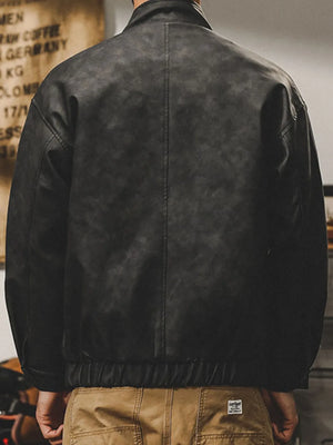 Distressed dark gray leather bomber jacket with stand collar and elastic hem.