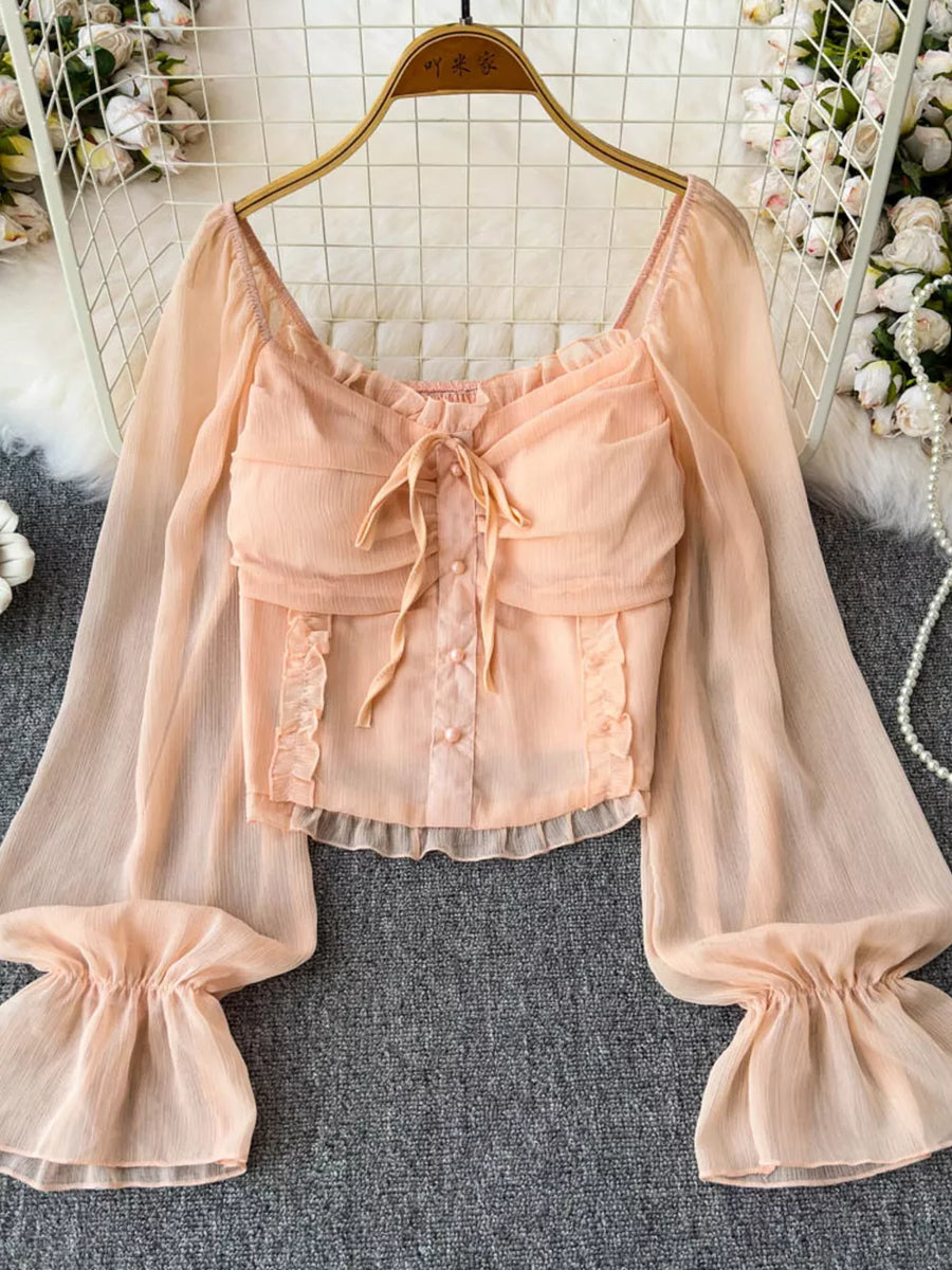 Peach ruffled sleeve maternity blouse with tie front and button detail.