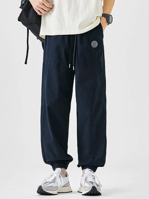 Navy blue relaxed fit joggers with drawstring and elastic cuffs.