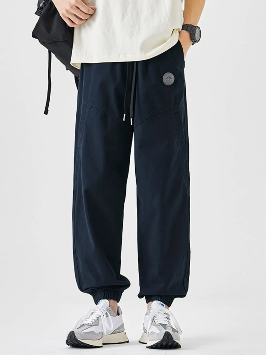 Navy blue relaxed fit joggers with drawstring and elastic cuffs.