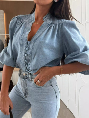 Button-down puff sleeve denim blouse in sky blue with a V-neckline and gathered shoulders.