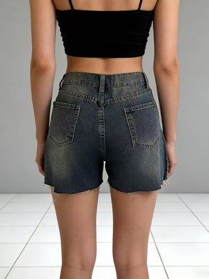 Dark wash denim shorts with frayed hem and distressed details