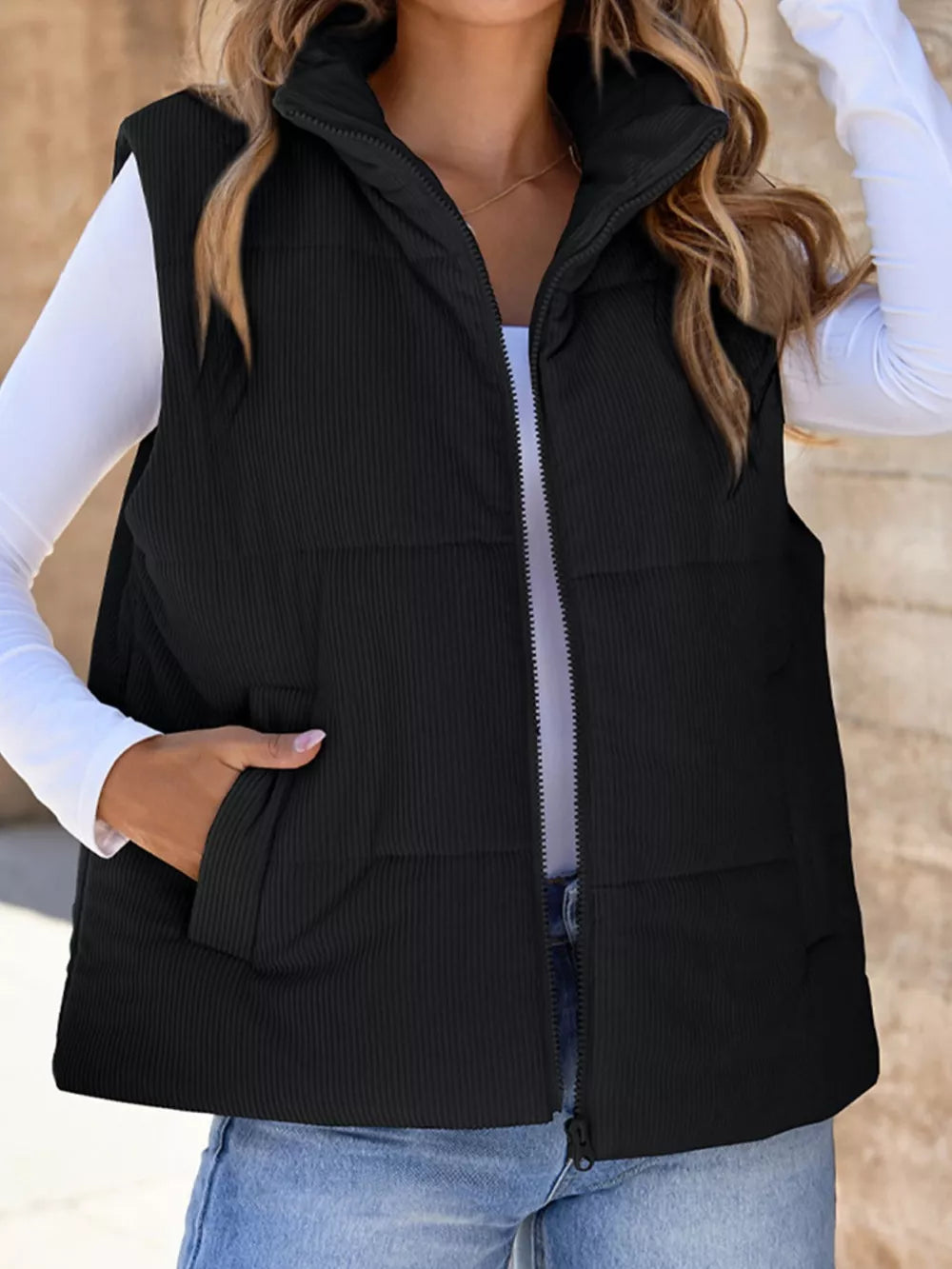 Black ribbed corduroy zip-up vest coat with stand collar and pockets.
