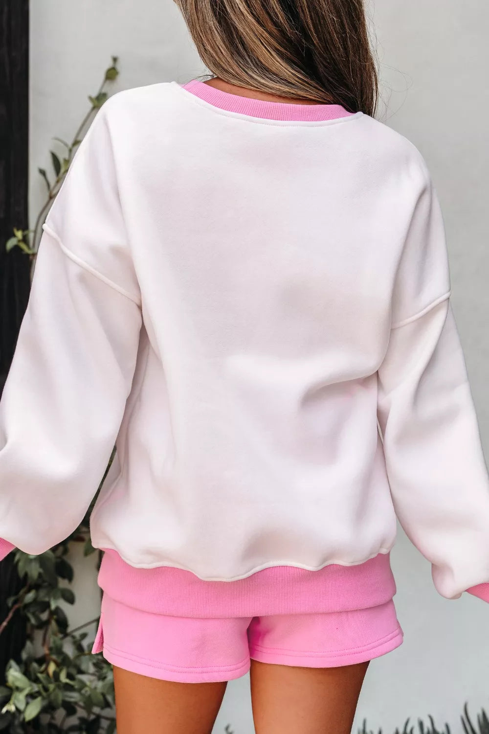White cotton sweatshirt with pink trim and matching pink shorts