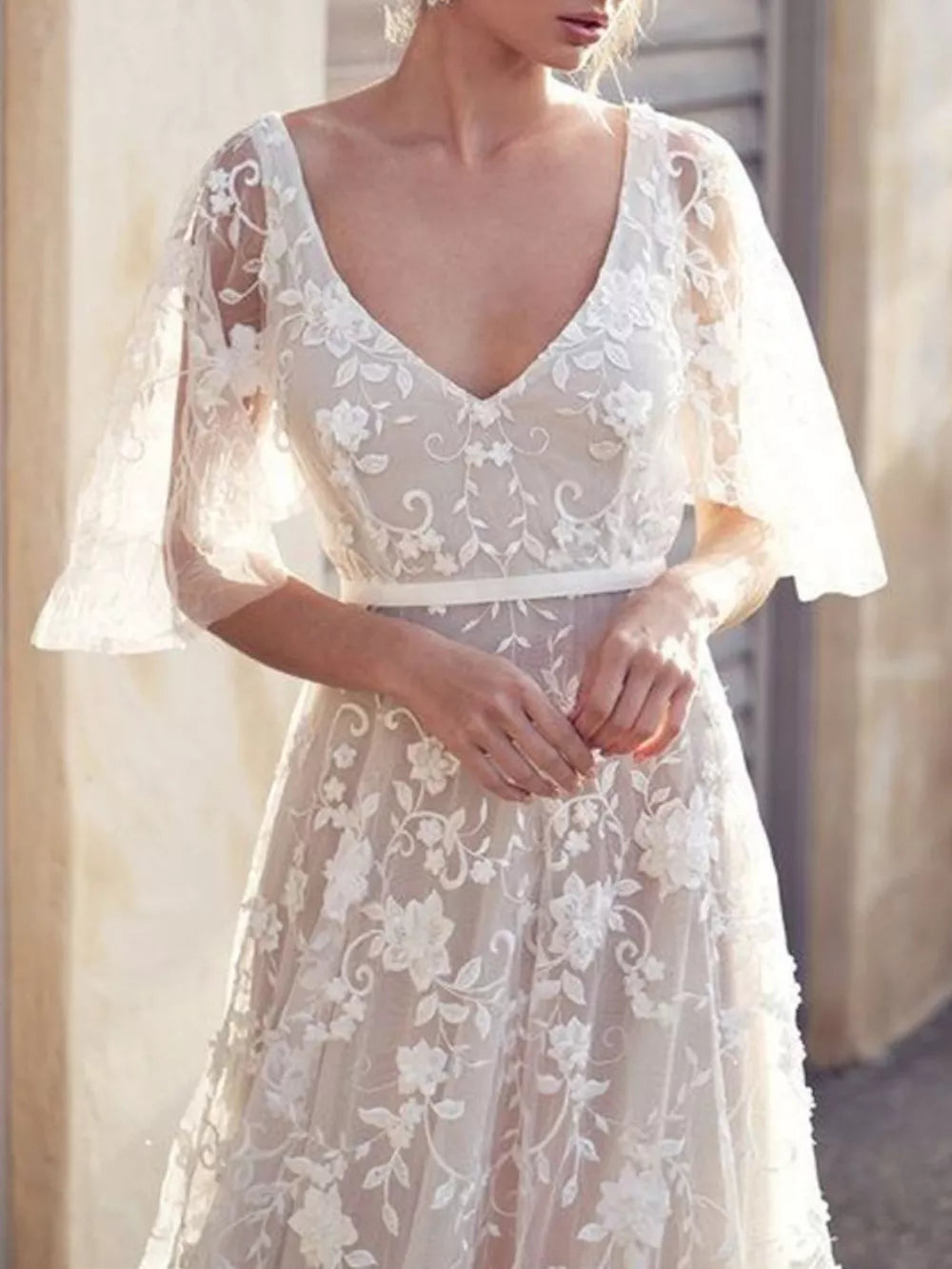 White lace flutter sleeve v-neck dress with floral embroidery and a satin belt.
