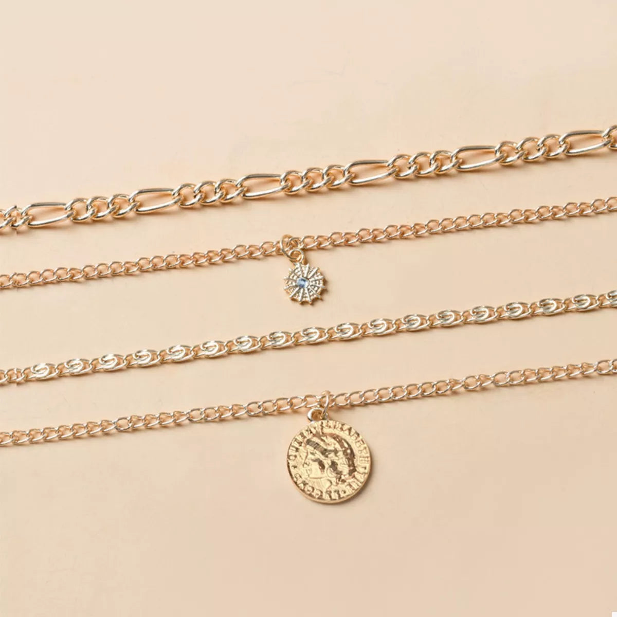 Layered gold necklaces with coin and starburst pendants