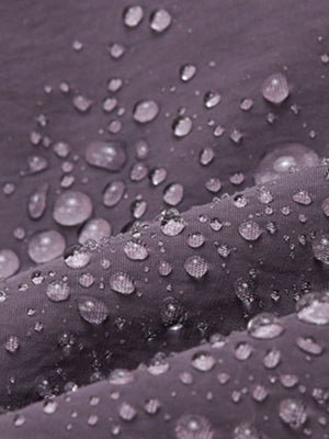 Mini Oxford cloth backpack in purple with water droplets showing breathable, water-resistant fabric.