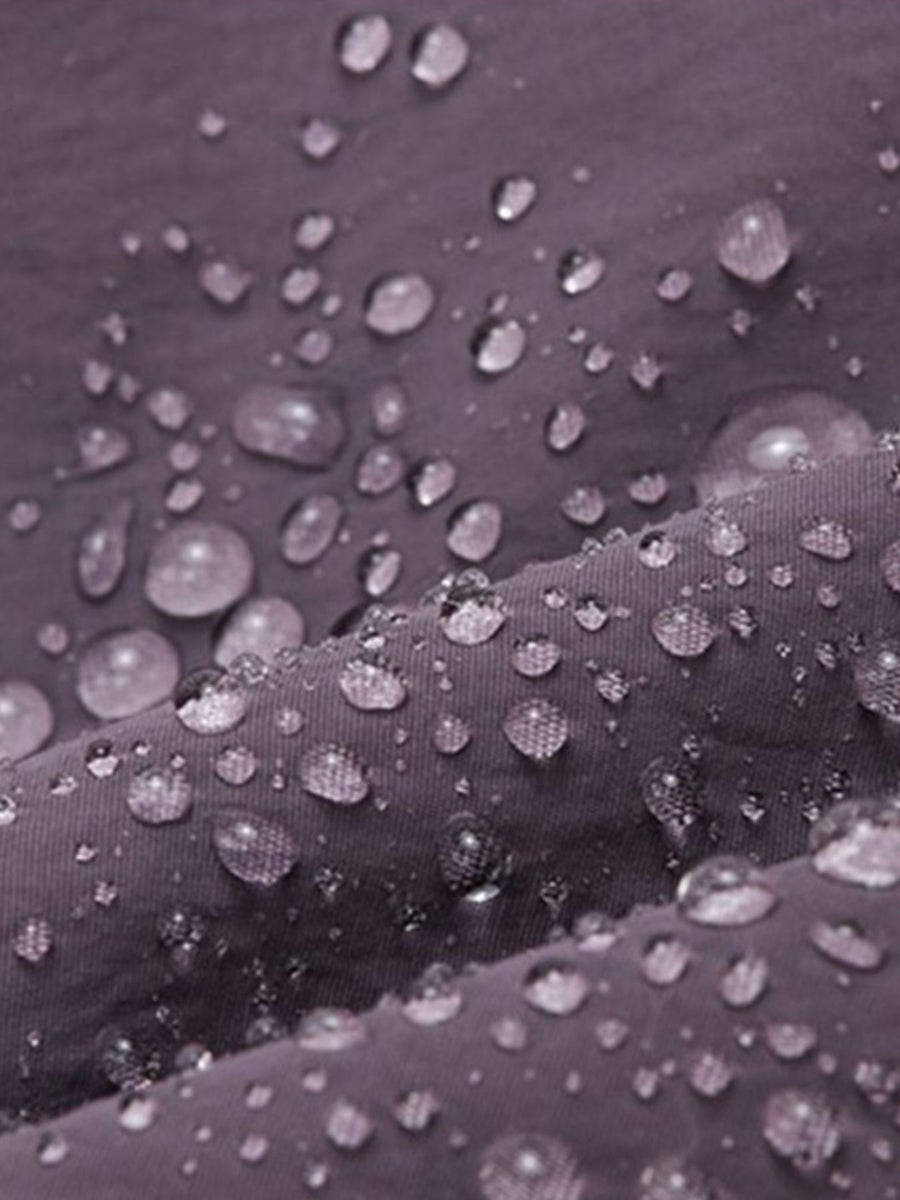 Mini Oxford cloth backpack in purple with water droplets showing breathable, water-resistant fabric.