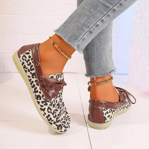 Leopard print boat shoes with brown leather trim and tie laces.