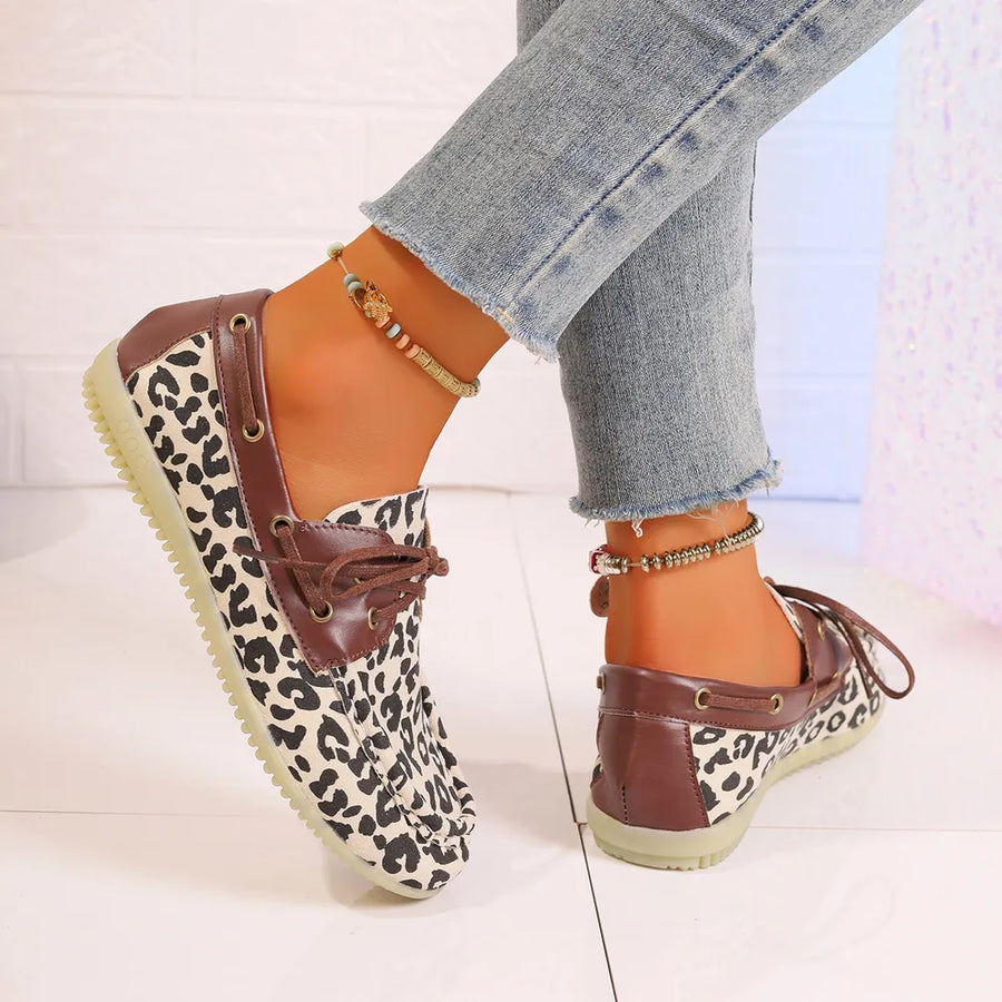 Leopard print boat shoes with brown leather trim and tie laces.