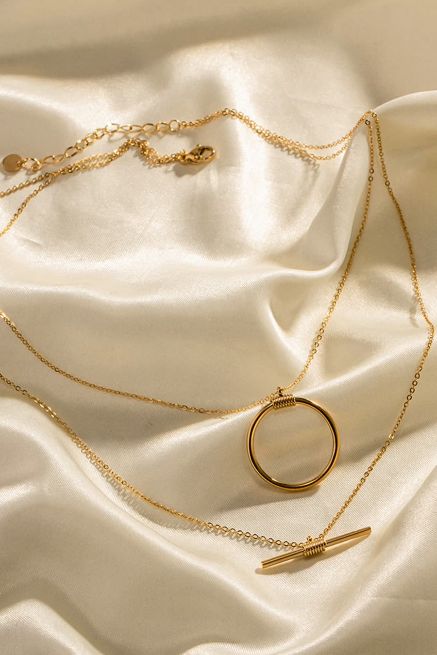 Gold double-layered necklace with geometric circle and bar pendants