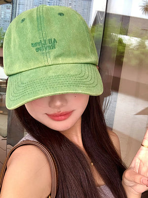 Olive green baseball cap with embroidered text and stitched brim detail