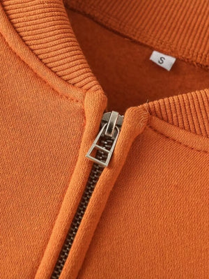 Orange casual zip-up top detail with silver zipper and size S tag.