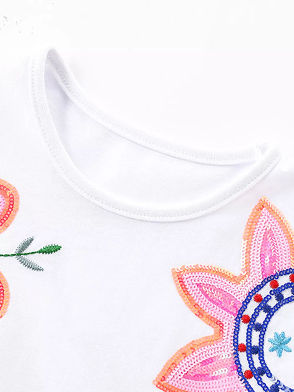 White cotton baby dress with floral embroidery and sequins.
