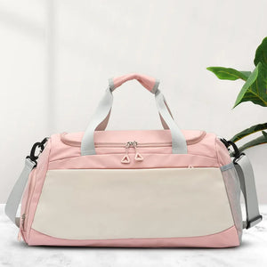 Blush pink and beige colorblock duffel bag with dual zippers and side mesh pockets.