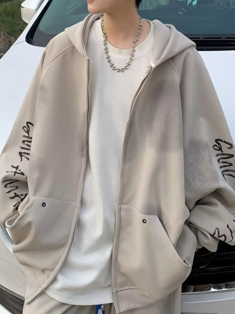 Oversized zip-up hoodie in apricot with graphic print on sleeves and front pockets.