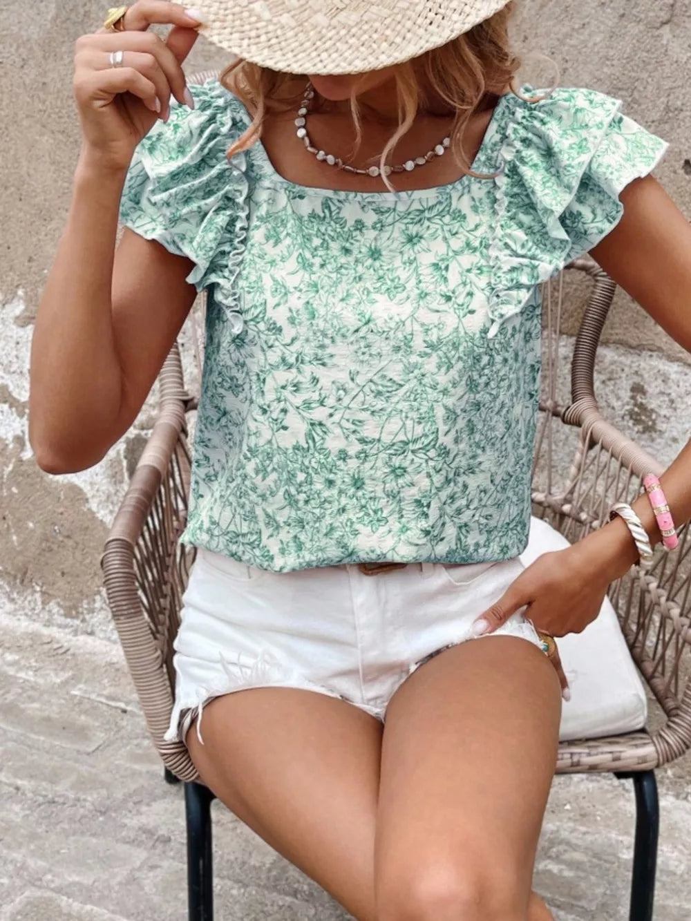 Green floral ruffle blouse with square neckline and short sleeves.