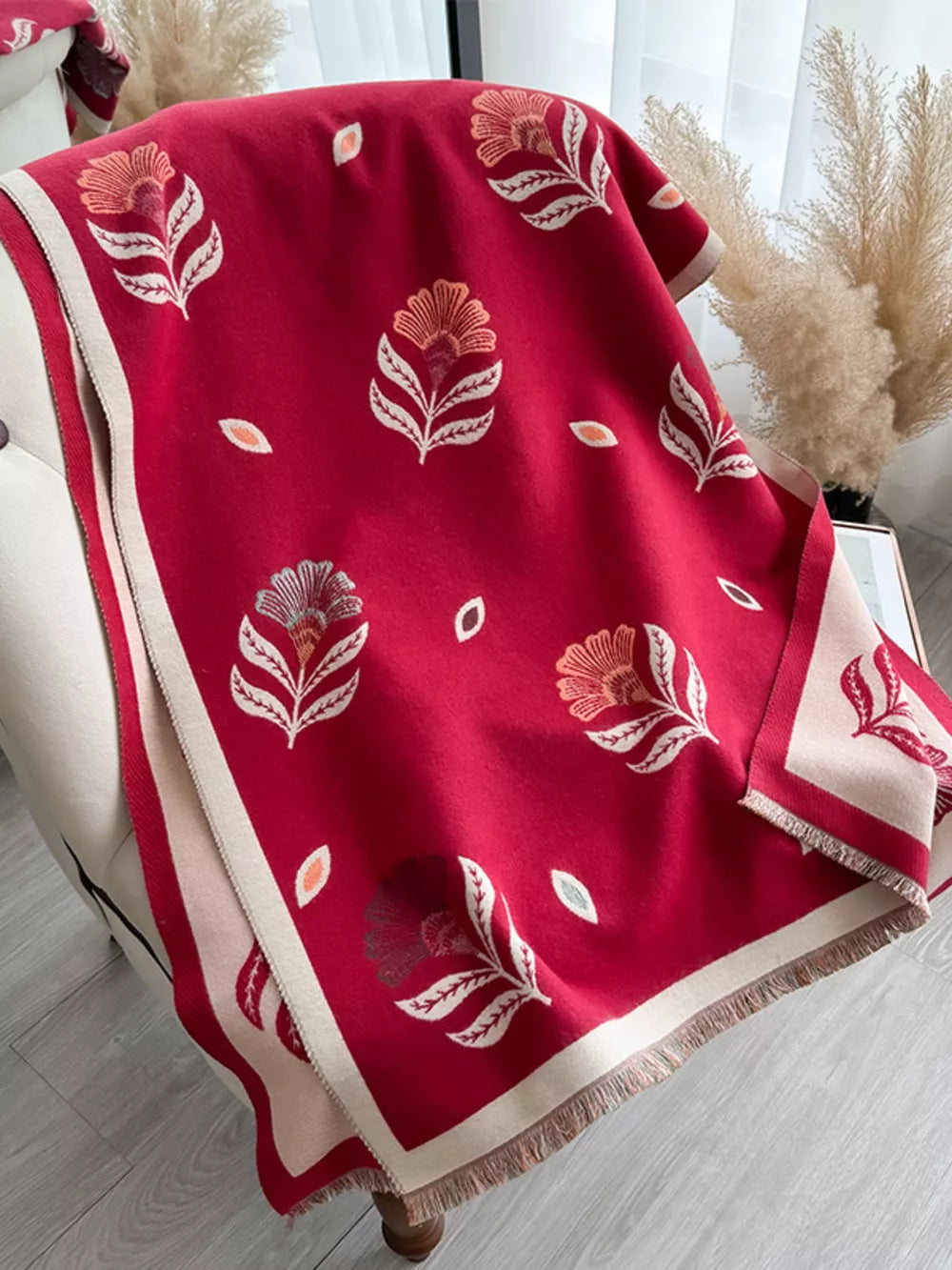 Red floral print fringed shawl with cream border and tassels.