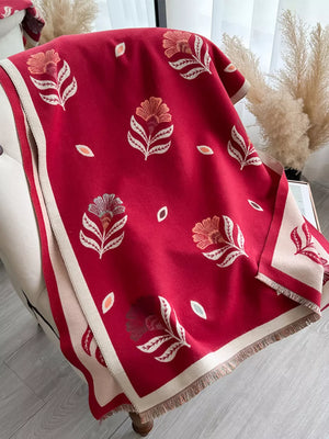 Red floral print fringed shawl with cream border and tassels.
