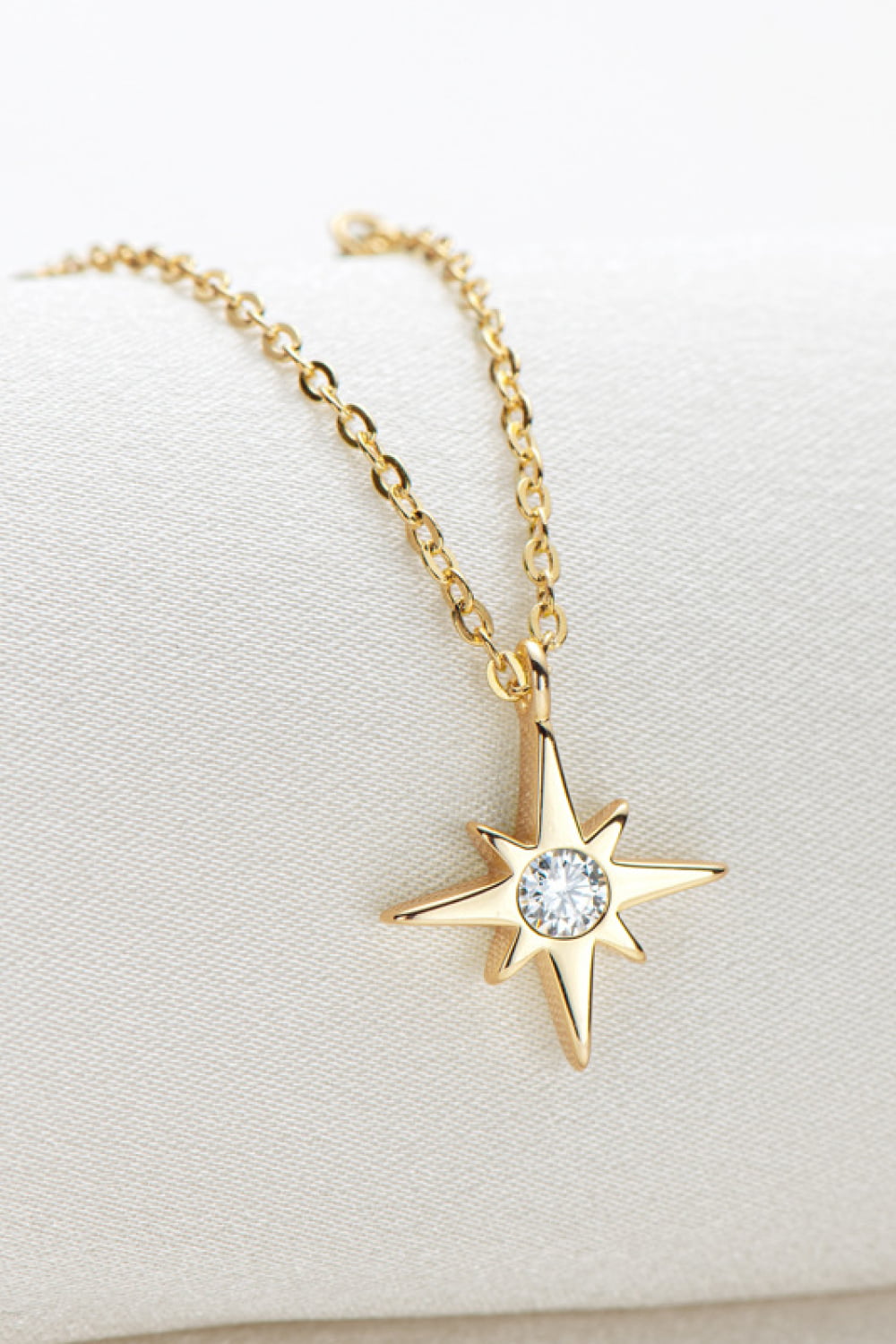 Gold celestial compass pendant necklace with moissanite on a delicate chain.