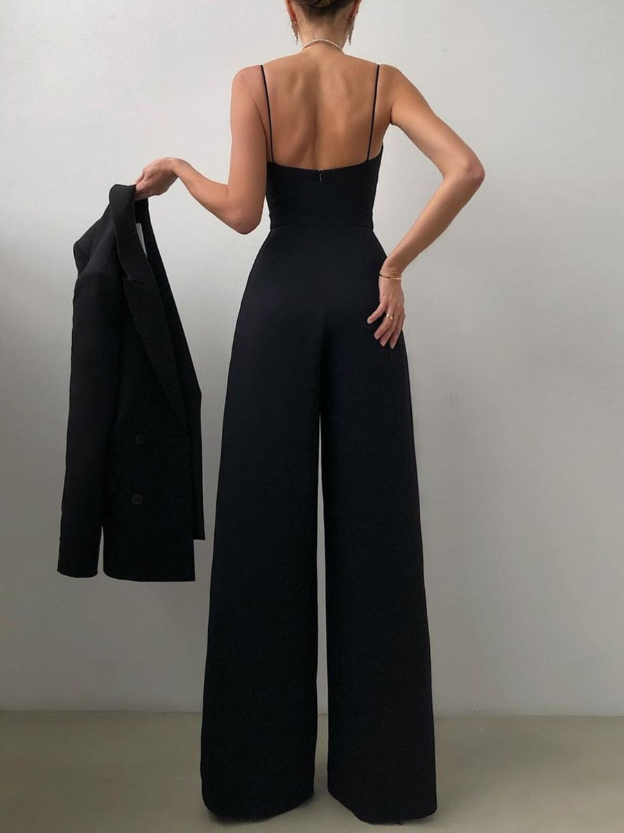 Black ruched spaghetti strap wide-leg jumpsuit with a blazer draped over the arm.