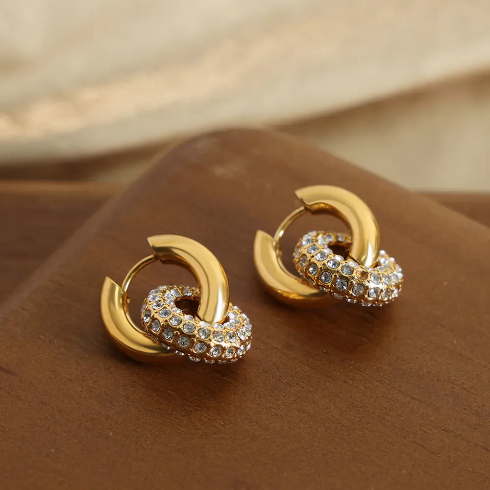 Gold pavé circle interlock hoop earrings with crystal accents.