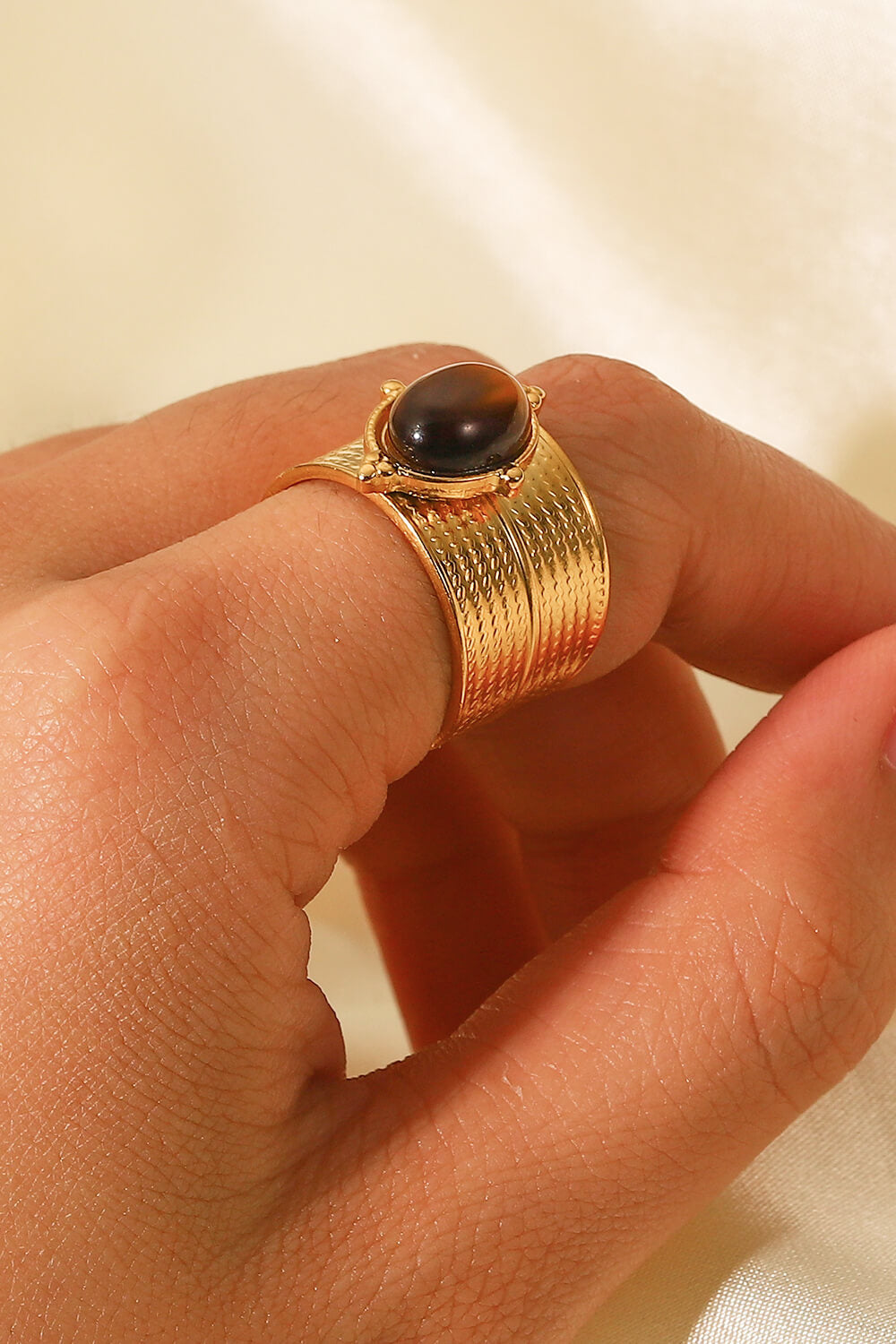 Textured tiger's eye cuff ring in brown with gold-tone band.