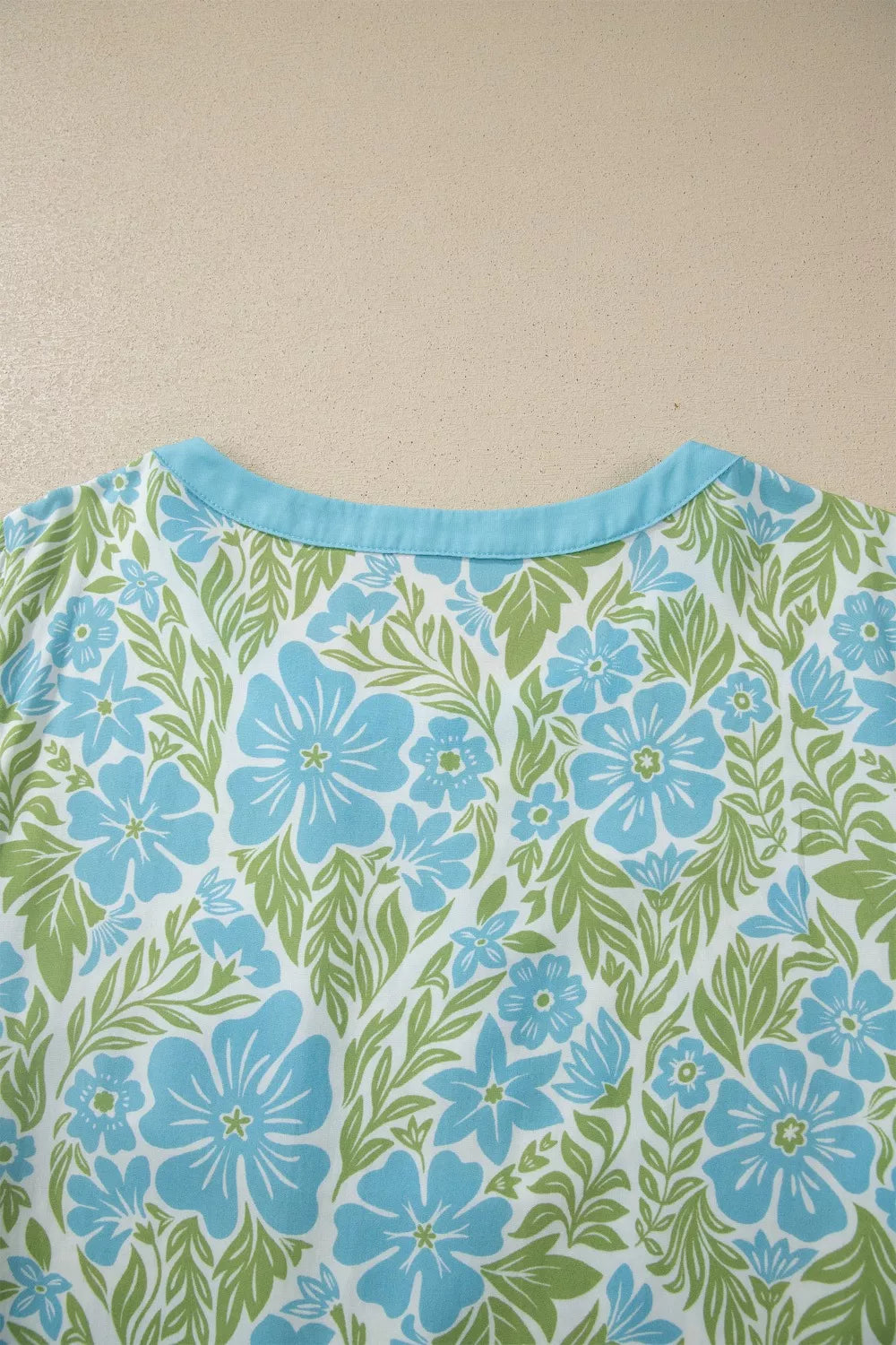 Floral ruffled half sleeve maternity blouse with blue flowers and green leaves pattern.