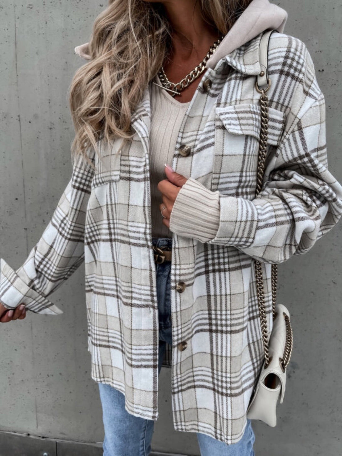 Oversized plaid shacket with attached hood in beige and white, featuring buttoned front and chest pockets.