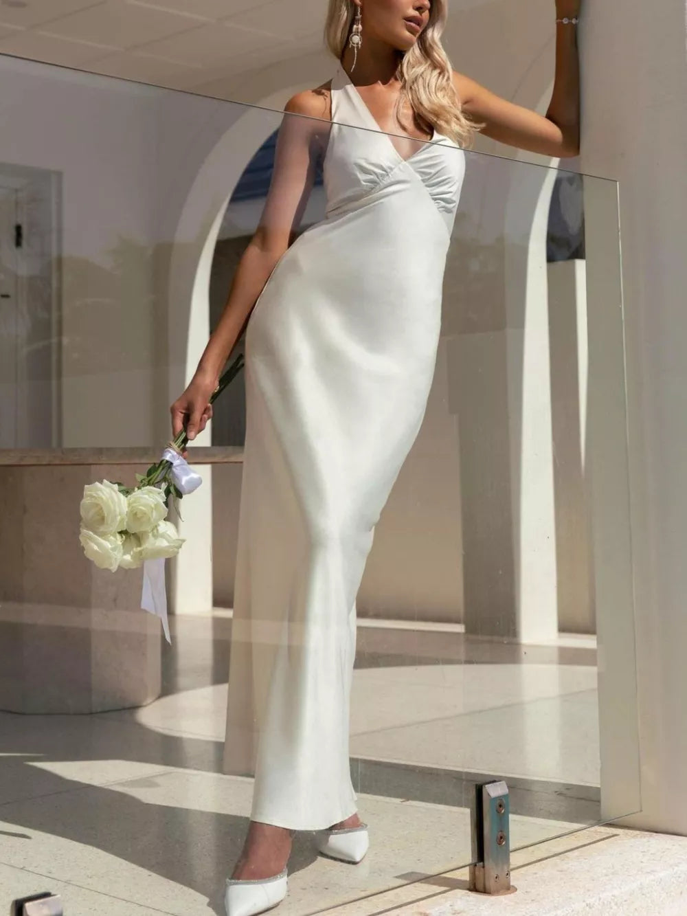 White backless halter neck maxi dress with ruched bodice and cotton fabric.