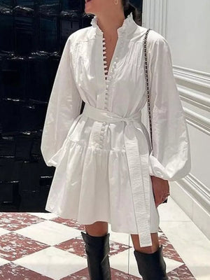 White cotton dress with ruffled collar, balloon sleeves, tiered skirt, and tie waist.