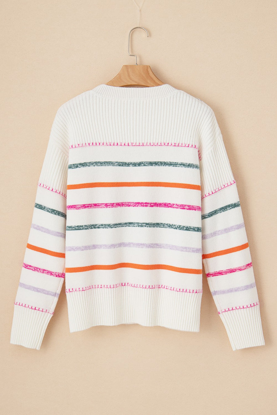 White ribbed knit pullover sweater with colorful horizontal stripes and crew neck.