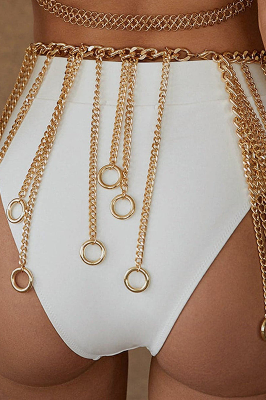 Gold chainmail belt with cascading chains and rings, styled over white bottoms.