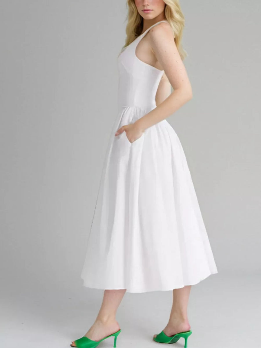 White halter neck midi dress with pockets and a full skirt.