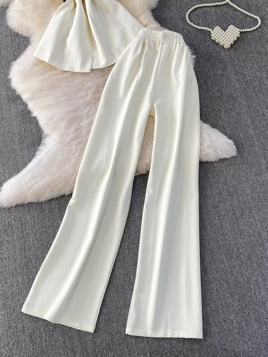 White belted two-piece set with wide leg pants and a cropped top, featuring pockets.