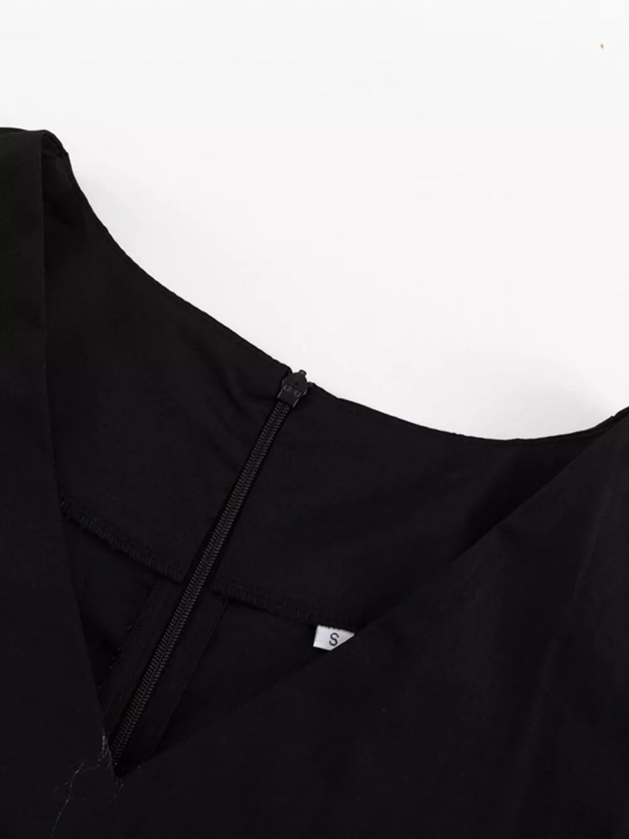 Black V-neck dress with a zipper closure and size tag.