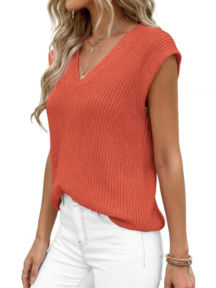 Textured apricot V-neck sweater vest with cap sleeves, styled with layered necklaces.
