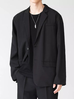 Men's black lapel collar button up blazer with two button closure and flap pockets.
