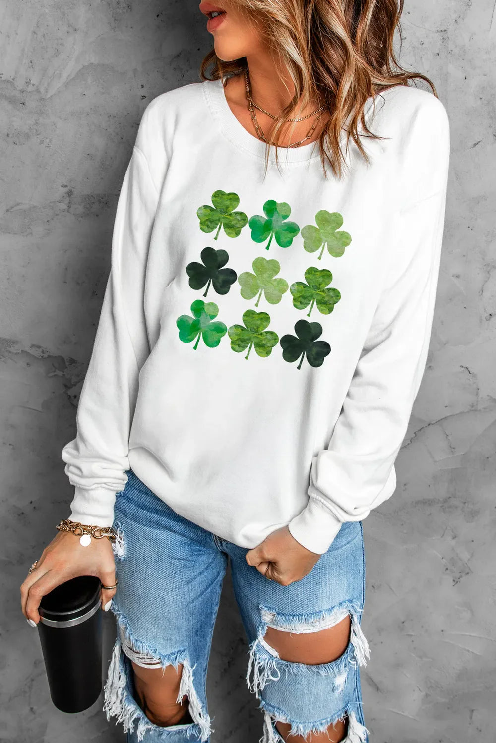 White crewneck sweatshirt with a grid of green clover prints.