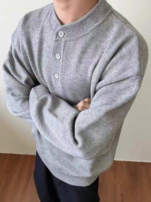 Grey knit sweater with button placket and long sleeves
