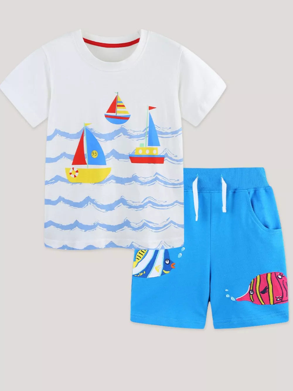 White cotton tee with sailboats and blue shorts with fish print for boys.