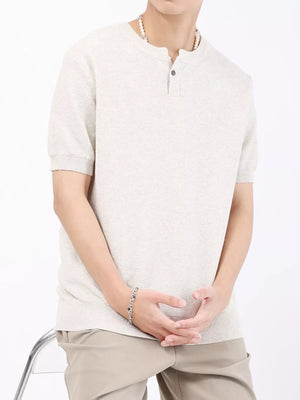 Men's casual knitted henley shirt in a light neutral color with short sleeves and a two-button placket.