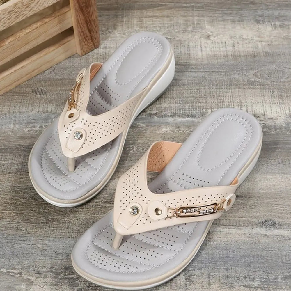 Perforated thong wedge sandals in beige with rhinestone embellishments.