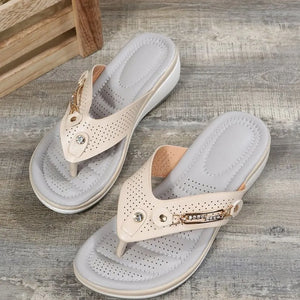 Perforated thong wedge sandals in beige with rhinestone embellishments.