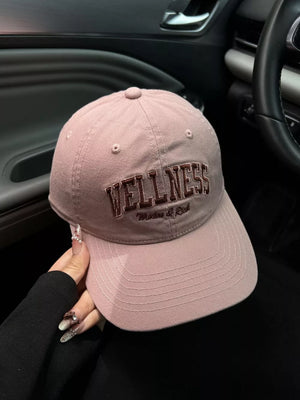 Pink cotton baseball cap with embroidered WELLNESS text