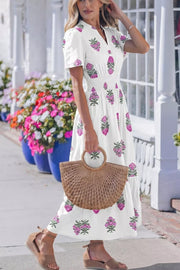 White cotton midi dress with pink floral print, V-neck, puff sleeves, and smocked waist.