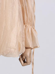 Romantic off-shoulder ruffled blouse in champagne color, with billowy sleeves and adjustable ties.