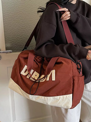 Chic color-blocked travel bag with adjustable strap and large capacity.