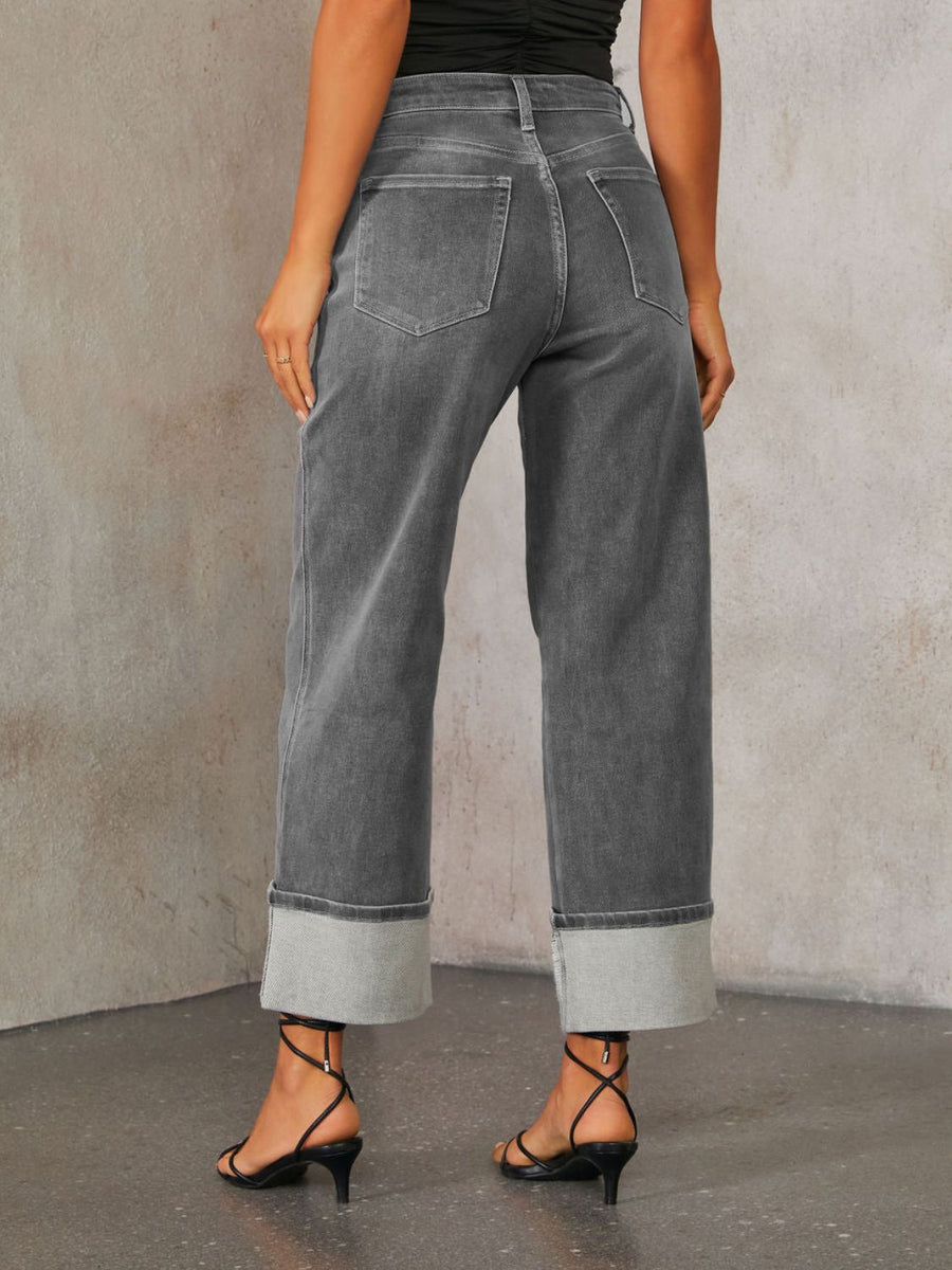 Dark wash denim jeans with wide legs and cuffed hems.